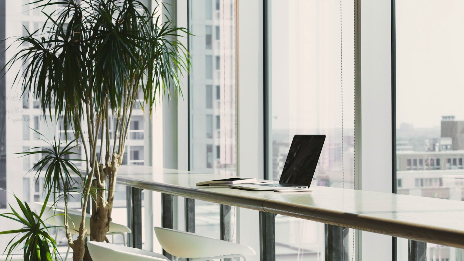 A sleek high-rise office with an empty desk by floor-to-ceiling windows, a picture of outer career success that can feel hollow inside.